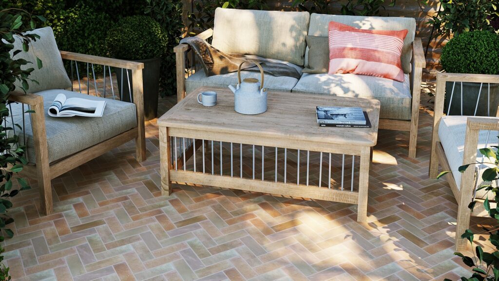 The patio features herringbone-patterned terracotta tiles in warm, earthy tones, creating a visually appealing surface.