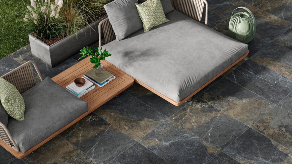 A luxurious outdoor living space featuring dark, multi-toned patio tiles.
